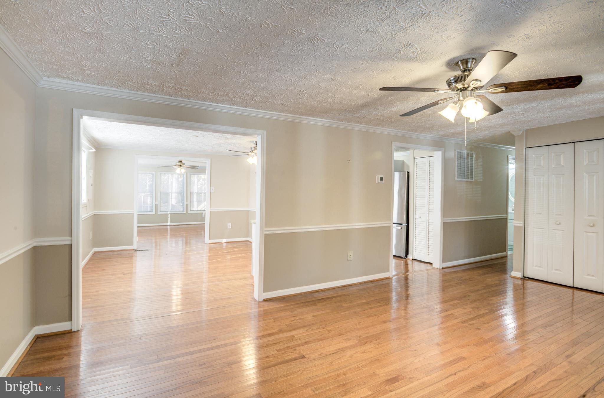 9 Burr Hill Drive Ocean Pines, MD 21811 - Photo 39 of 82 a view of a livingroom with wooden floor a ceiling fan and windows