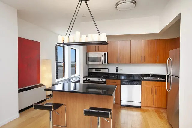 a kitchen with stainless steel appliances granite countertop a stove a sink and a microwave