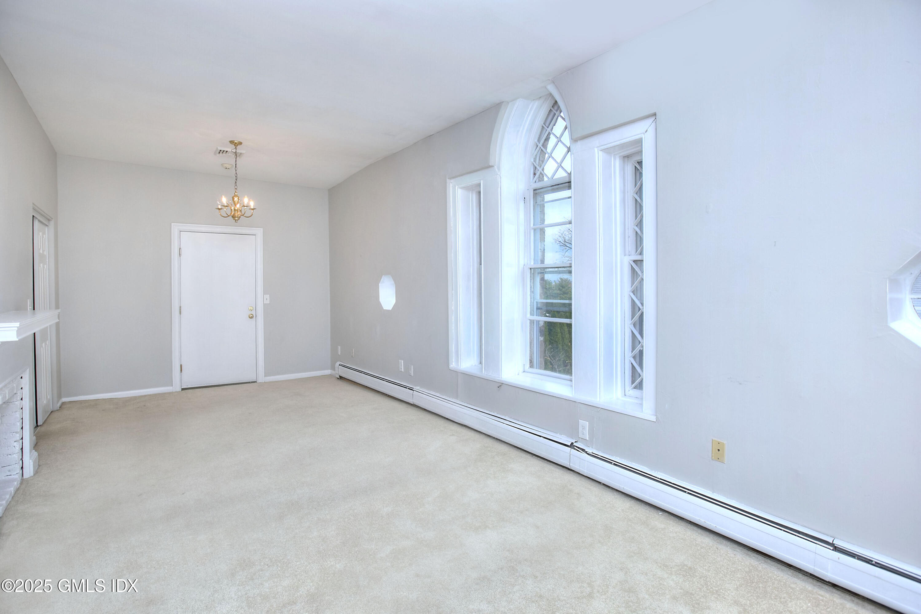 300 Soundview Avenue, Unit DUPLEX Fairfield, CT 06825 - Photo 17 of 27 an empty room with chandelier fan and windows