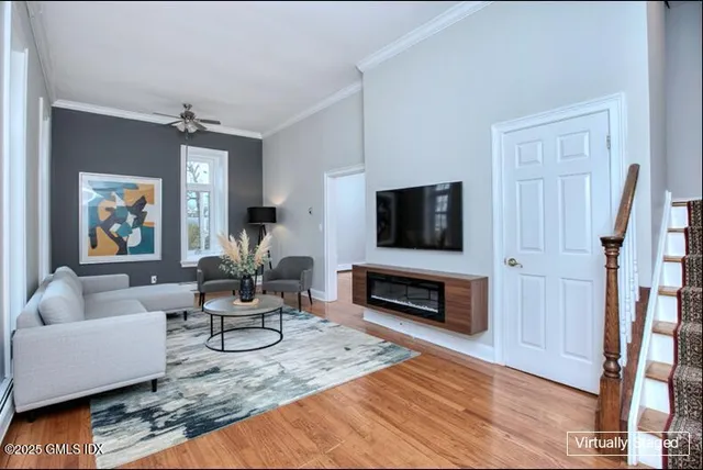 a view of empty room with wooden floor and fan