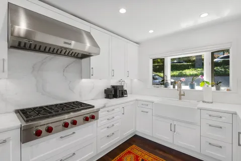 a kitchen with white cabinets and appliances