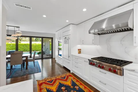 a kitchen with granite countertop a stove and white cabinets