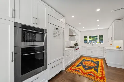 a kitchen with stainless steel appliances granite countertop a refrigerator and a stove top oven