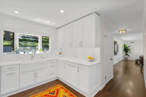 a view of a kitchen with a sink and dishwasher with wooden floor