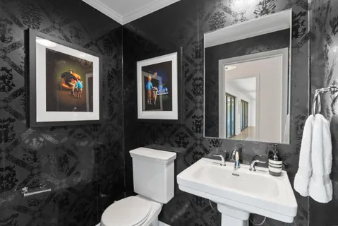 a bathroom with a toilet sink and mirror