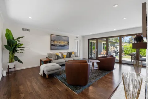 a living room with furniture floor to ceiling window and wooden floor
