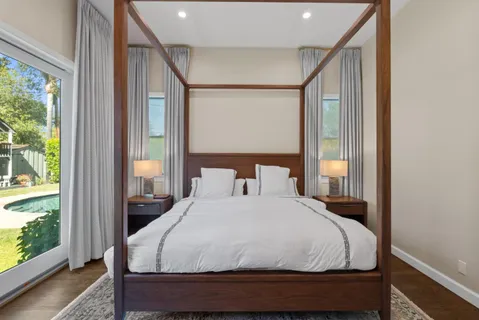 a large bed sitting in a bedroom next to a window