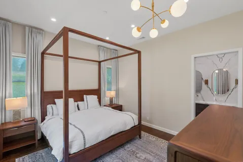 a bedroom with a bed and a flat tv screen on dresser