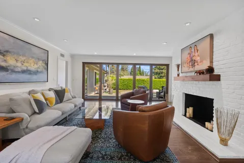 a living room with furniture a large window and a fireplace