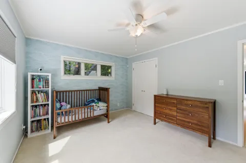 a bedroom with furniture and baby crib