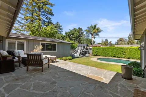 a view of a house with swimming pool and a yard