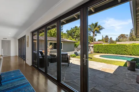 a view of a living room and floor to ceiling window wooden floor