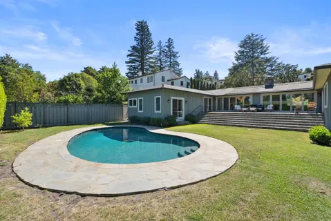 a view of a house with swimming pool and deck