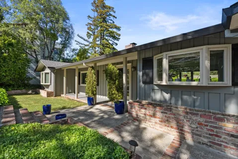 a view of a house with backyard and sitting area