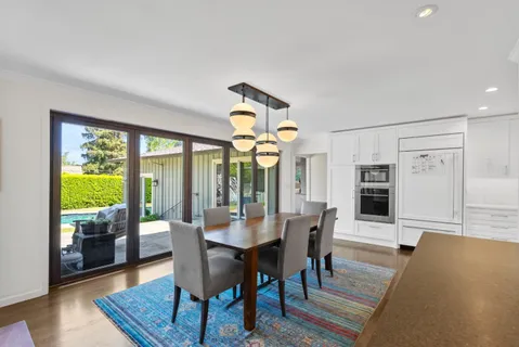 a view of a a dining room with furniture window and wooden floor