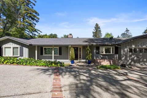 a front view of a house with lots of green space