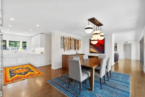 a view of a dining room with furniture a chandelier and wooden floor