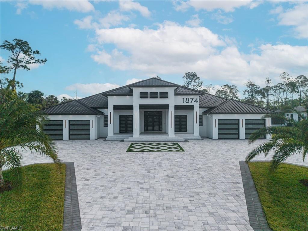 1874 39th Street Southwest Naples, FL 34117 - Photo 1 of 50 a front view of a house with garden