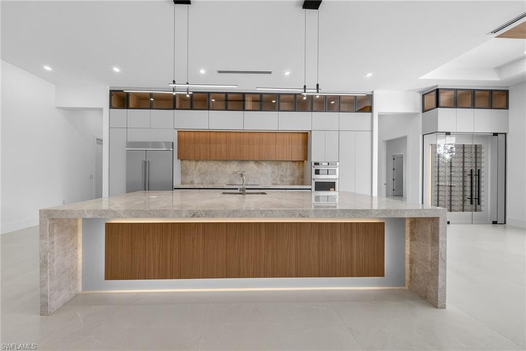 1874 39th Street Southwest Naples, FL 34117 - Photo 10 of 50 a kitchen with stainless steel appliances granite countertop a stove a sink and a microwave
