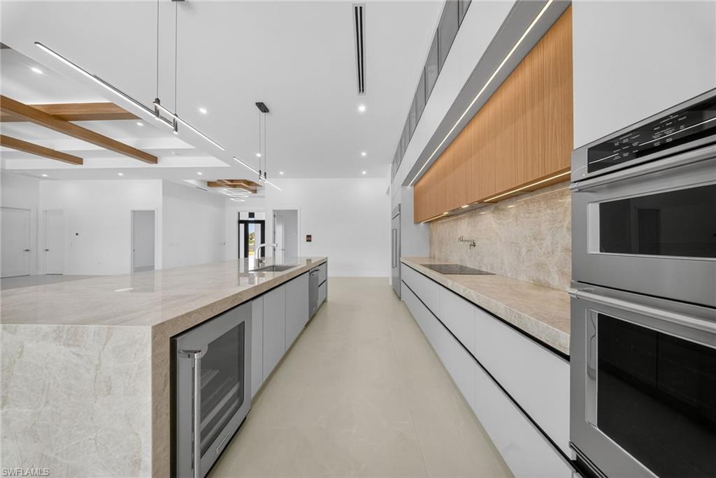 1874 39th Street Southwest Naples, FL 34117 - Photo 12 of 50 a large white kitchen with stainless steel appliances