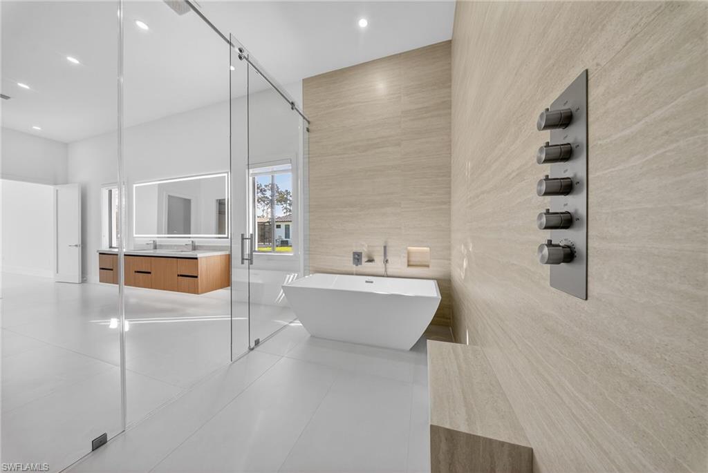 1874 39th Street Southwest Naples, FL 34117 - Photo 20 of 50 a bathroom with a bathtub a sink and a mirror