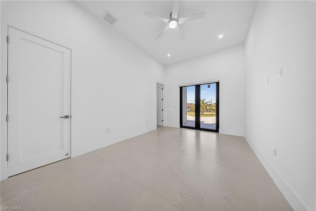 1874 39th Street Southwest Naples, FL 34117 - Photo 25 of 50 an empty room with chandelier fan and windows