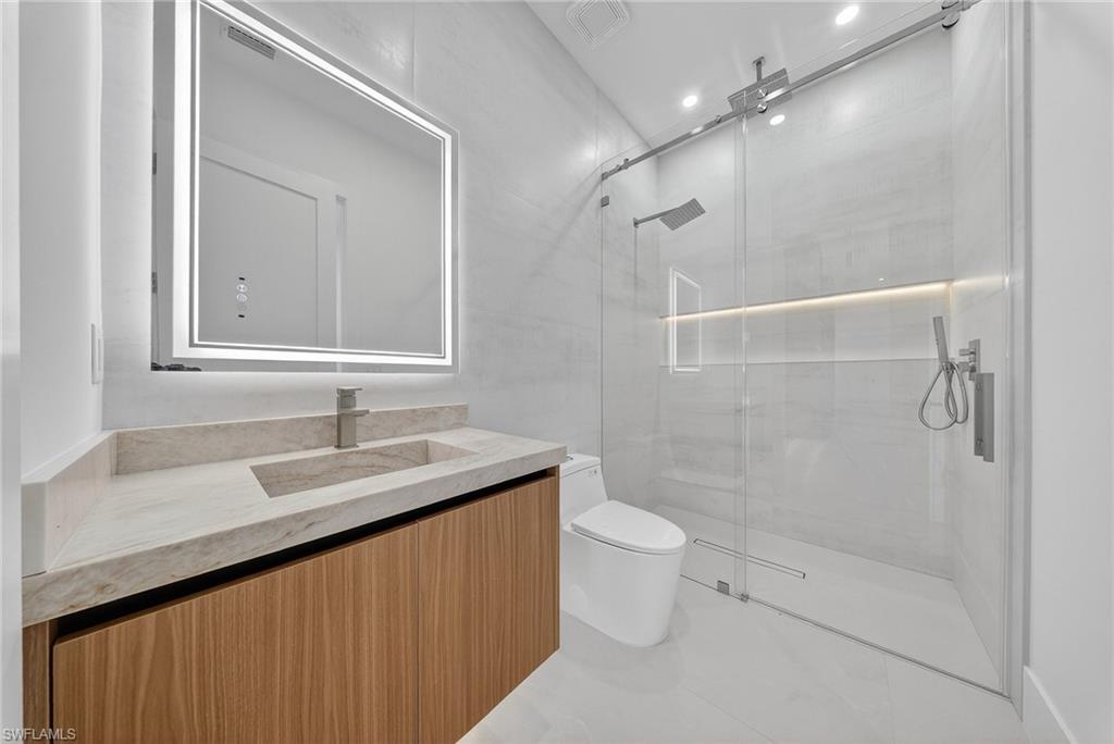 1874 39th Street Southwest Naples, FL 34117 - Photo 28 of 50 a bathroom with a granite countertop sink a toilet and shower