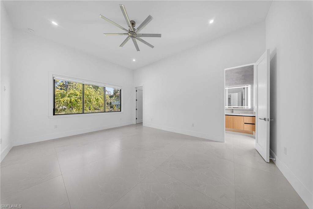 1874 39th Street Southwest Naples, FL 34117 - Photo 29 of 50 an empty room with windows and ceiling fan