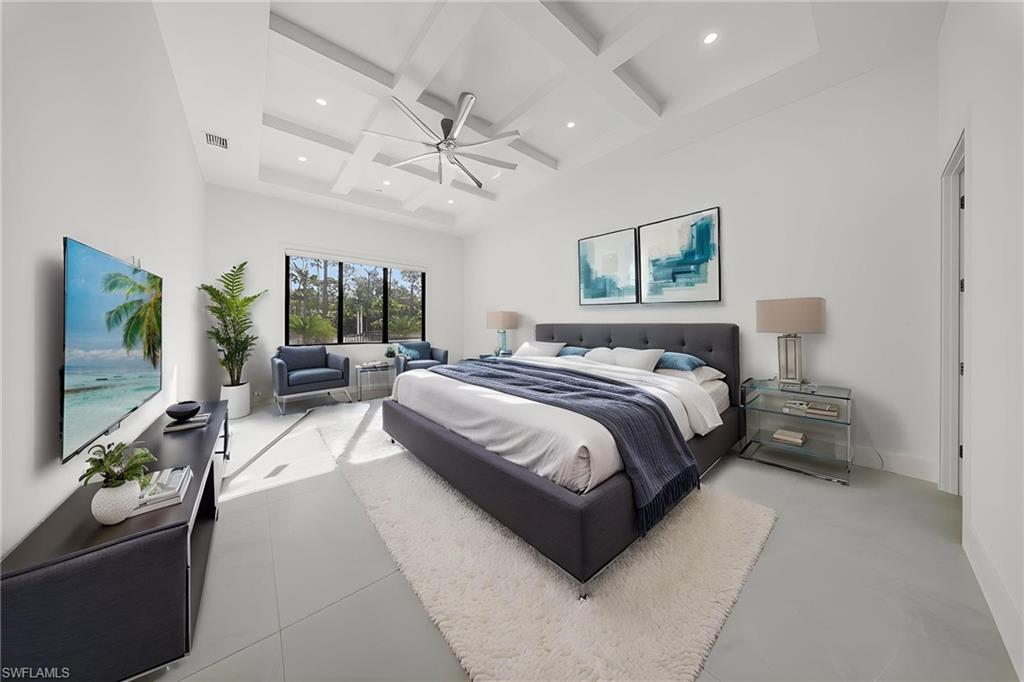 1874 39th Street Southwest Naples, FL 34117 - Photo 45 of 50 a spacious bedroom with a bed a couch and a flat screen tv