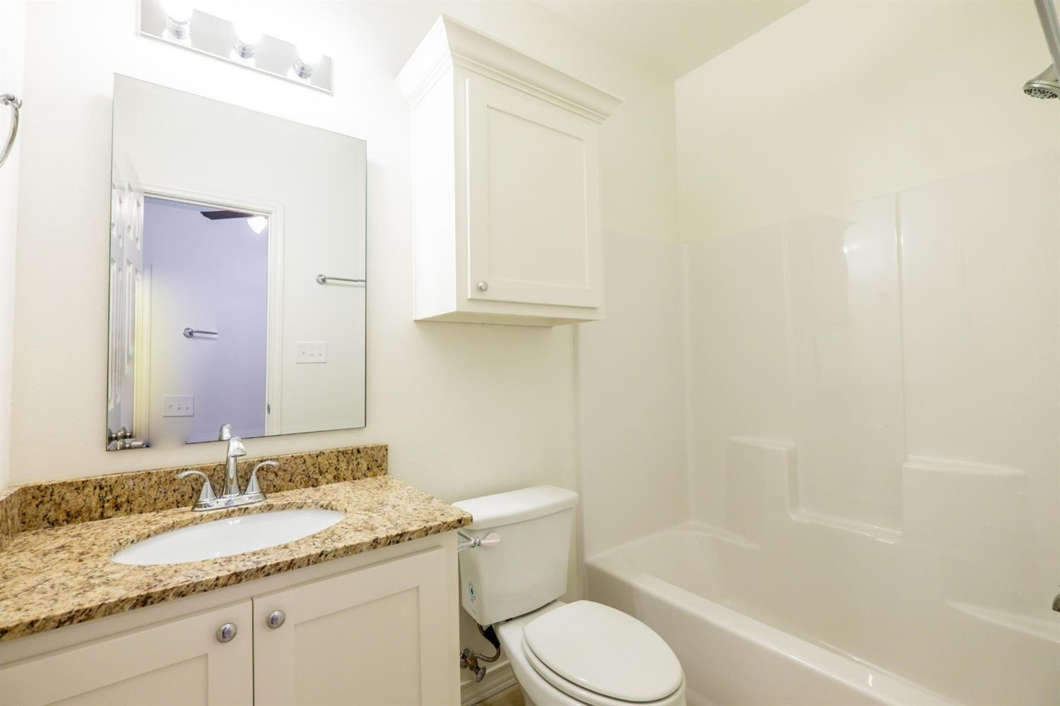 2311 20th Street Lubbock, TX 79411 - Photo 14 of 18 a bathroom with a granite countertop sink toilet and shower