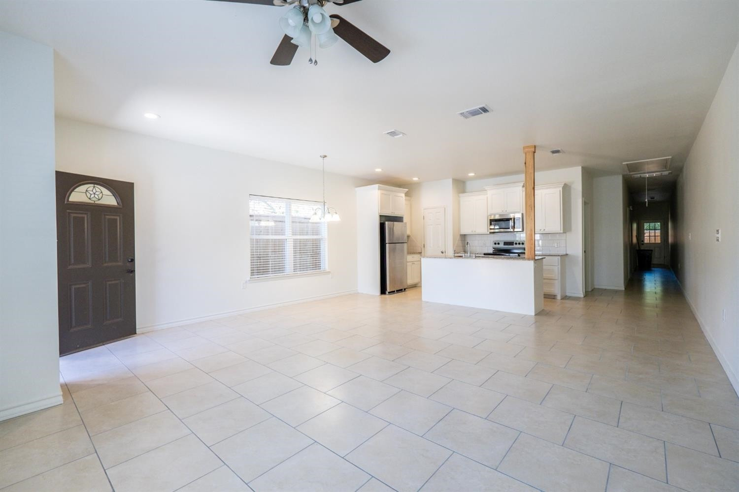 2311 20th Street Lubbock, TX 79411 - Photo 3 of 18 a view of a electric appliances in kitchen and empty room with windows