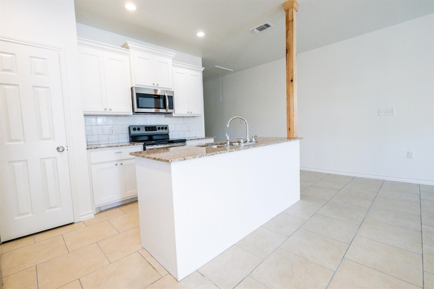 2311 20th Street Lubbock, TX 79411 - Photo 5 of 18 a kitchen with stainless steel appliances a sink a stove a microwave a sink a refrigerator and cabinets