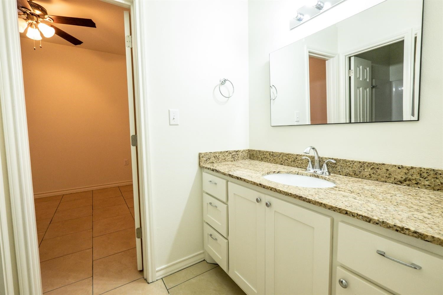2311 20th Street Lubbock, TX 79411 - Photo 7 of 18 a bathroom with a granite countertop sink and a mirror