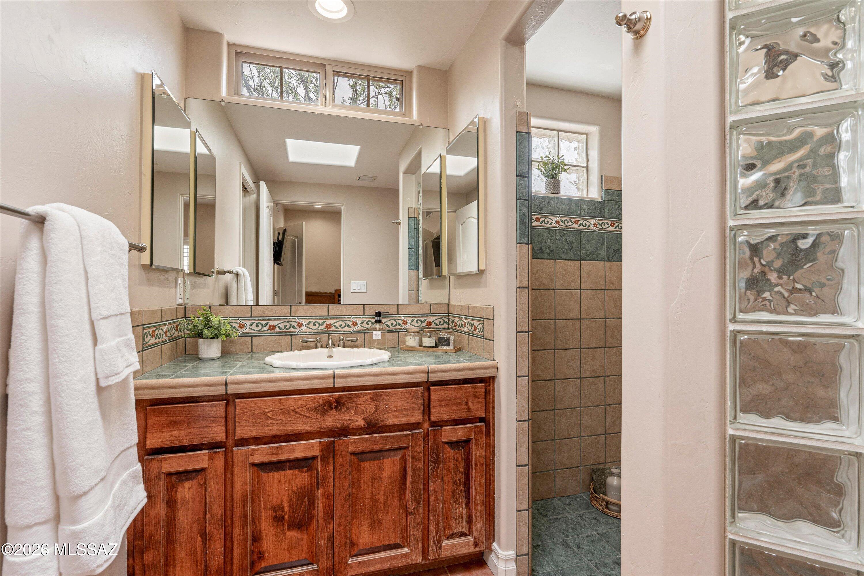 4760 East Wagon Train Road Tucson, AZ 85739 - Photo 29 of 38 a bathroom with a sink and a mirror