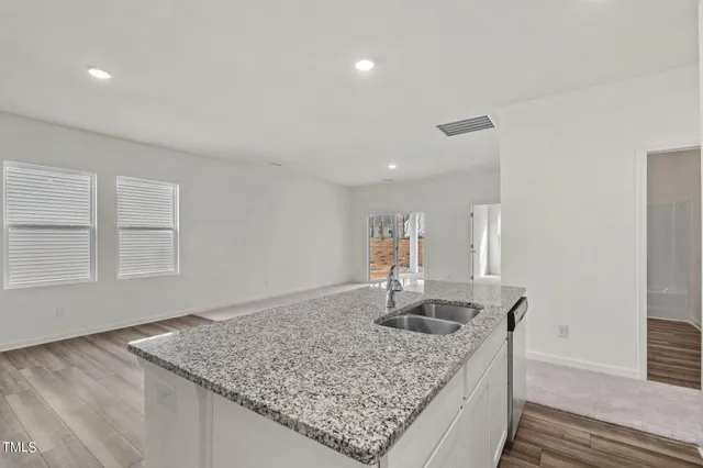 a kitchen with kitchen island granite countertop a sink window and refrigerator