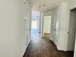 a view of a hallway with wooden floor