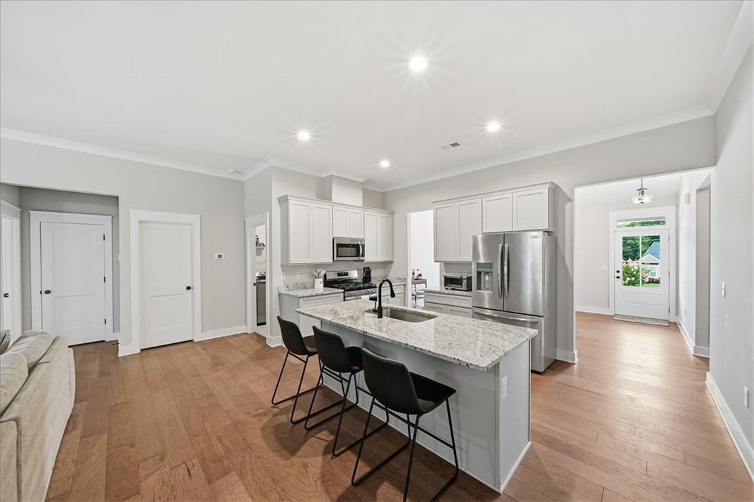 214 Timothy Court Anderson, SC 29621 - Photo 9 of 43 A contemporary kitchen space boasts an inviting island with granite counters and rich hardwood flooring throughout.