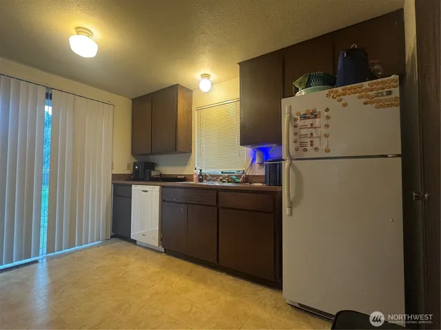a kitchen with cabinets a refrigerator and a sink