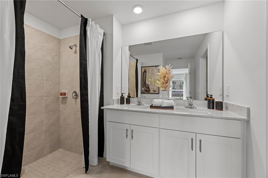 7178 Sugar Pine Way Fort Myers, FL 33966 - Photo 16 of 33 a bathroom with a double vanity sink and mirror