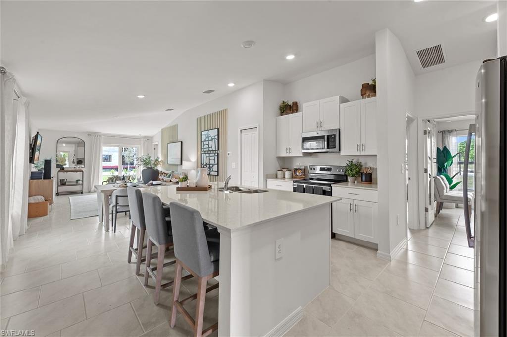 7178 Sugar Pine Way Fort Myers, FL 33966 - Photo 31 of 33 a kitchen with white cabinets and stainless steel appliances