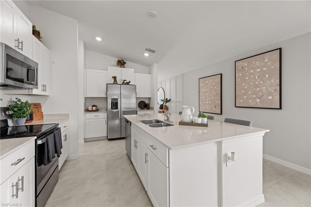7178 Sugar Pine Way Fort Myers, FL 33966 - Photo 5 of 33 a kitchen with white cabinets sink and stainless steel appliances