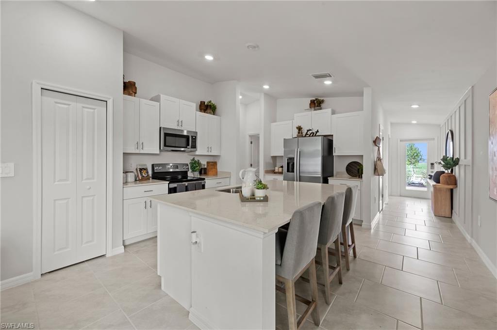7178 Sugar Pine Way Fort Myers, FL 33966 - Photo 6 of 33 a kitchen with kitchen island granite countertop a sink a counter top space stainless steel appliances and cabinets