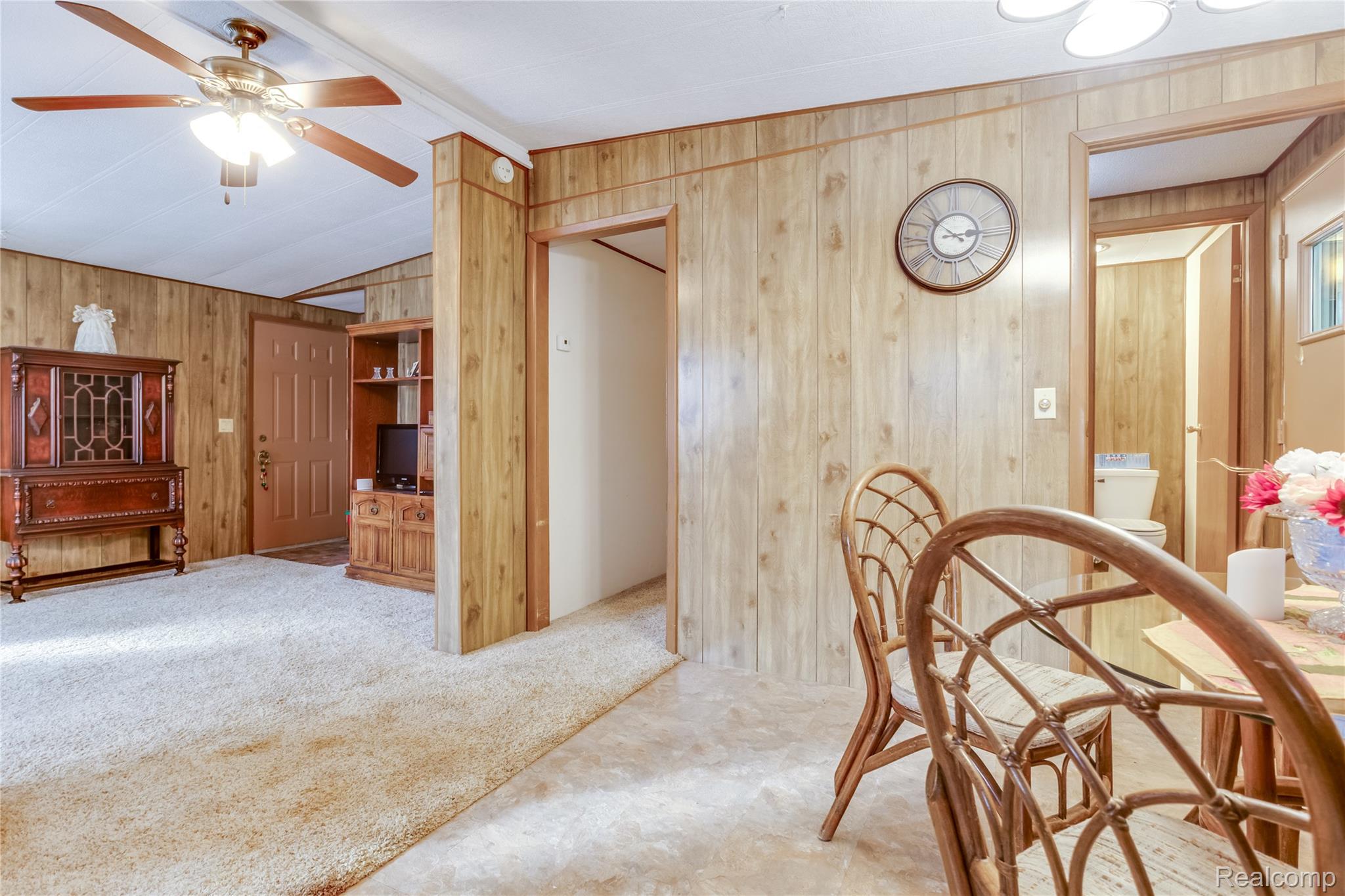 3333 Ravenswood Road Marysville, MI 48040 - Photo 7 of 25 Dining space featuring wood walls, a ceiling fan, an office area, carpet, and lofted ceiling