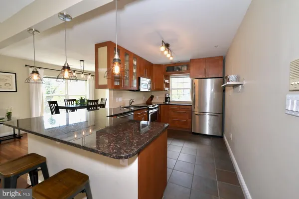 a kitchen with stainless steel appliances granite countertop a refrigerator a sink a stove and a microwave oven