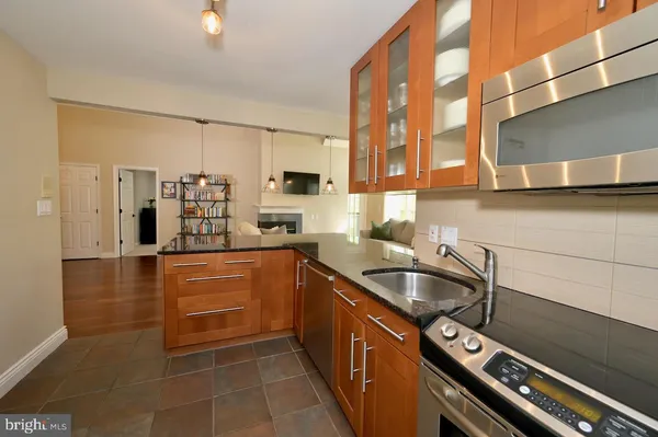 a kitchen with stainless steel appliances granite countertop a refrigerator a stove and a sink