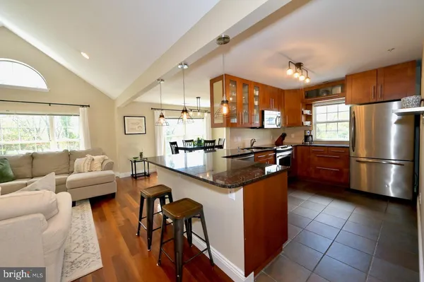 a kitchen with stainless steel appliances granite countertop a sink a stove and a refrigerator