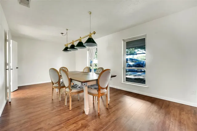 a dining room with furniture a chandelier and wooden floor