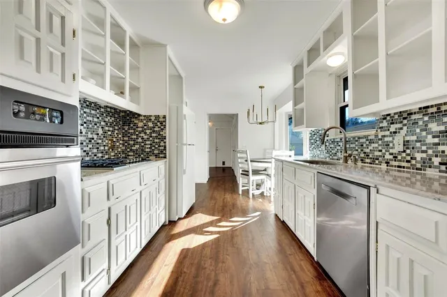 a kitchen with granite countertop white cabinets and black appliances