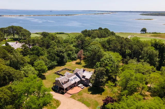 an aerial view of residential house with outdoor space and trees all around