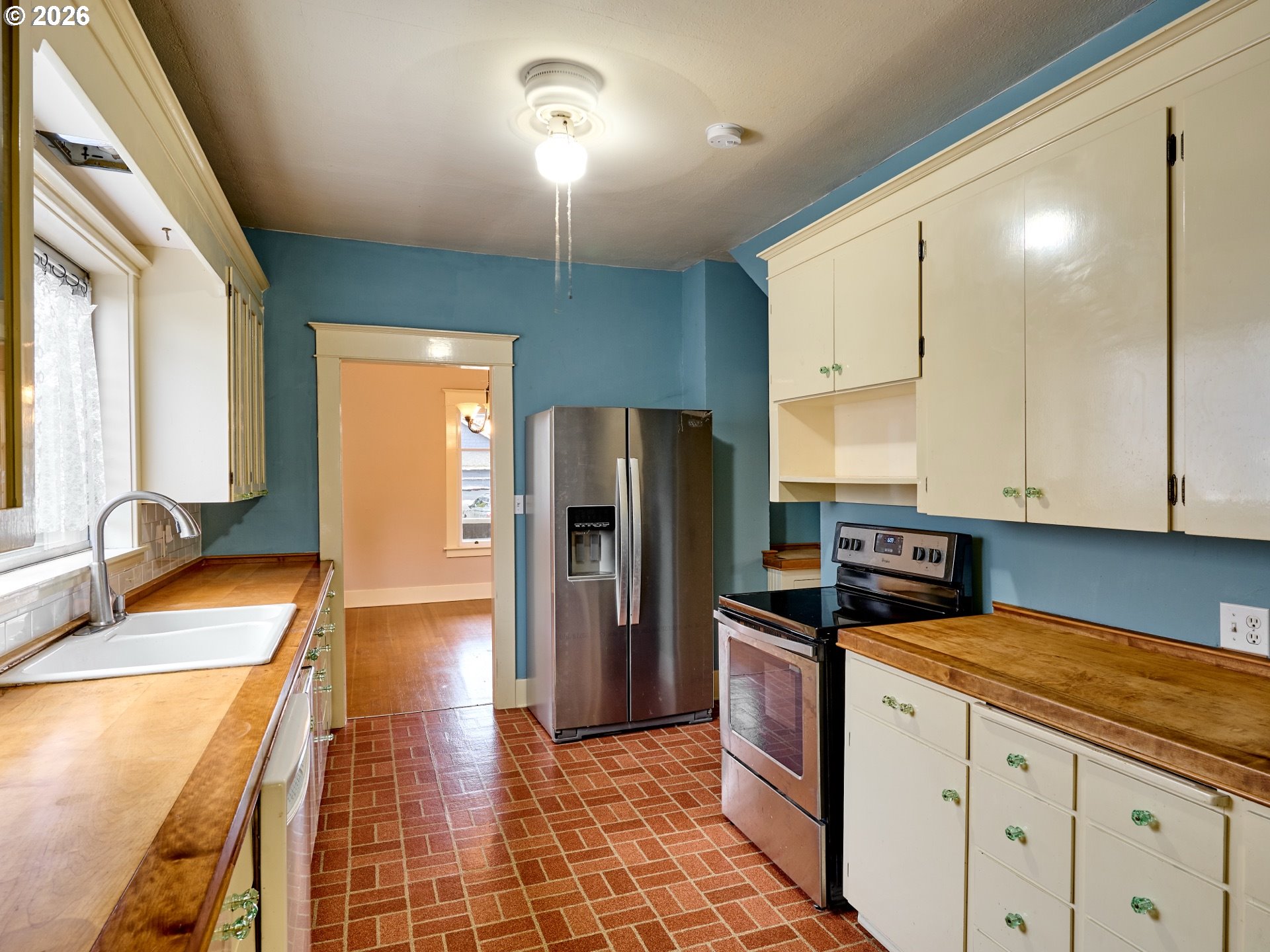 216 South James Street Silverton, OR 97381 - Photo 8 of 31 a kitchen with stainless steel appliances granite countertop a refrigerator a sink and white cabinets